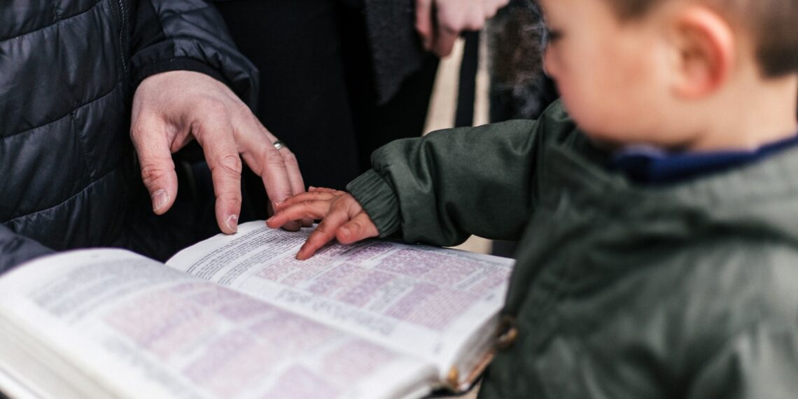 boy touching page of book